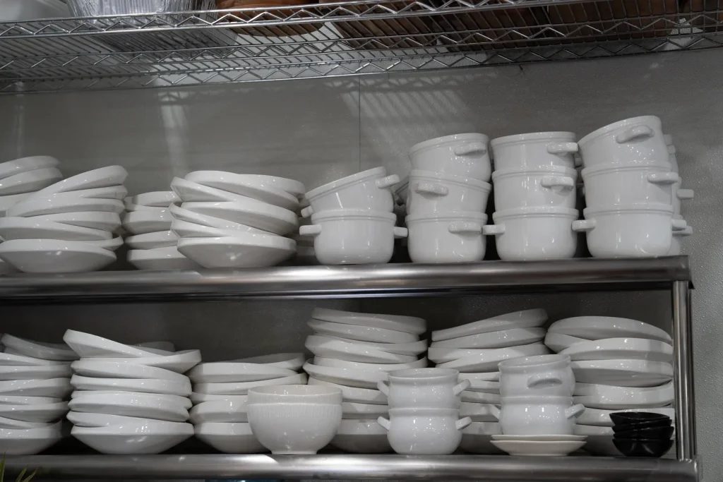 White plates and bowls neatly arranged in the Sowa kitchen.