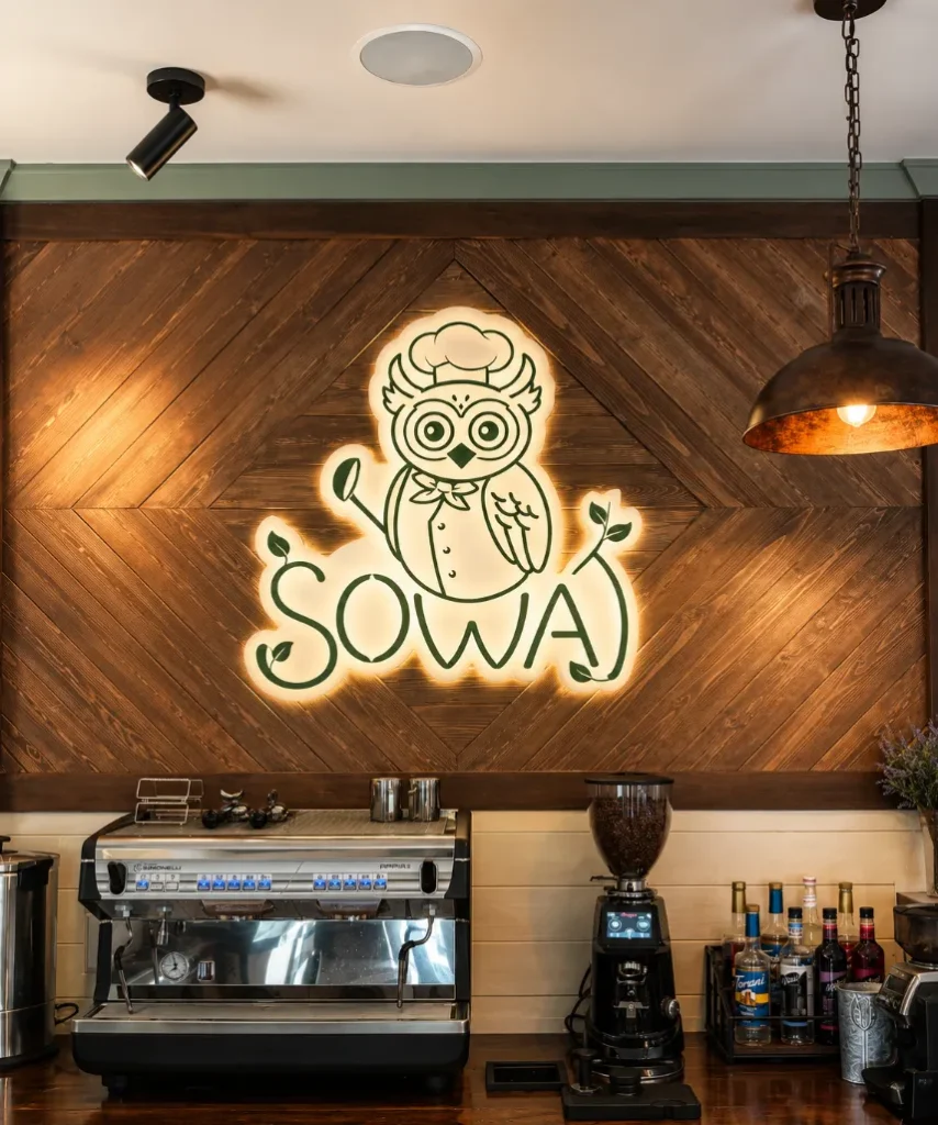 The illuminated Sowa owl logo above the restaurant coffee counter.