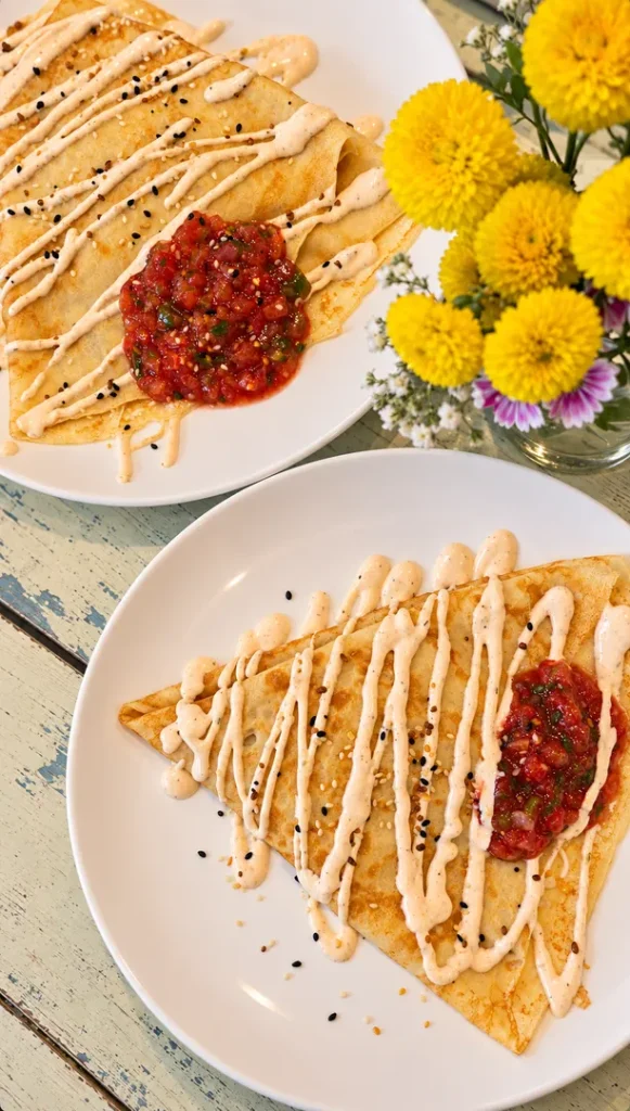Scrambled eggs and bacon crepes served with tomato salsa.